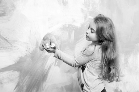 cute girl, happy small child with curly hair, rabbit or hare toy on colorful backgroundの写真素材