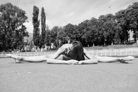Sport and yoga. Summer activity and energy. Coach and health. Girl sunny outdoor on fitness mat. Woman workout and stretching.の写真素材