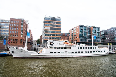 Hamburg, Germany - September 07, 2017: River transport, transportation. Ship at ferry pier on cityscape background. Water travel, travelling, trip. Vacation, discovery, wanderlust.のeditorial素材