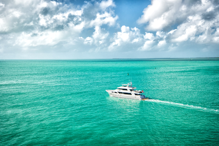 Adventure, discovery, journey. Yacht sail in turquoise sea on cloudy sky. Water transport, vessel, boat, transportation. Vacation, wanderlust, travelling. Luxury lifestyle concept.の写真素材