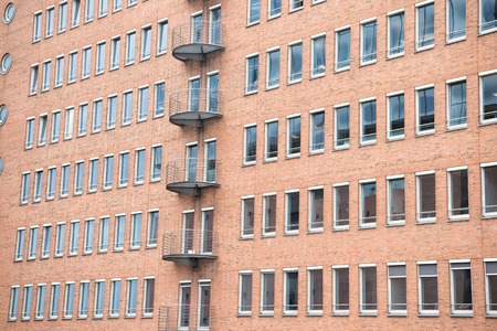 Building facade wall background of red bricks with windows in Hamburg, Germany. Business center, district. Architecture, structure, design.の写真素材