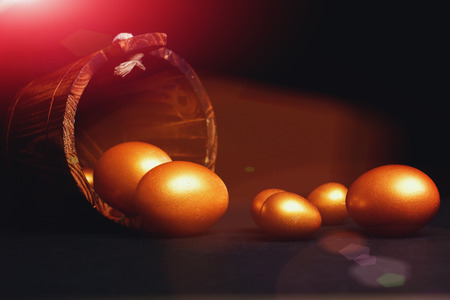 happy easter holidays egg traditional eggs painted in golden color inside wooden bucket isolated on black background. Happy Easter conceptの写真素材
