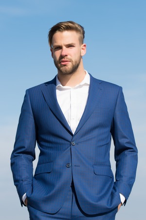 Fashion, style, lifestyle. Businessman stand on blue sky, success. Man in business suit, fashion. Success, ambition, freedom, achievement. Business, entrepreneurship, career.の写真素材