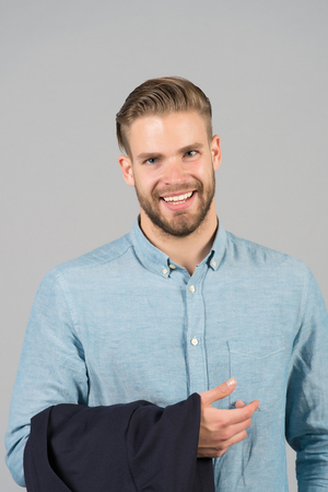 Man smile with bearded face and blond hair, haircut. Macho happy smiling in blue fashionable shirt, fashion. Mens fashion, style and trend. Grooming and hair care in beauty salon, barbershop.の写真素材