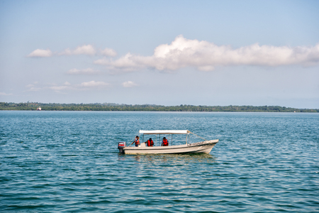 Santo tomas, Guatemala - February 23, 2016: people travel in motor boat in blue sea on cloudy sky. Travelling on boat, water transport. Summer vacation and wanderlust.のeditorial素材