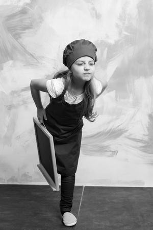 Happiness and childhood Small girl cook in a hat with blackboard.の写真素材