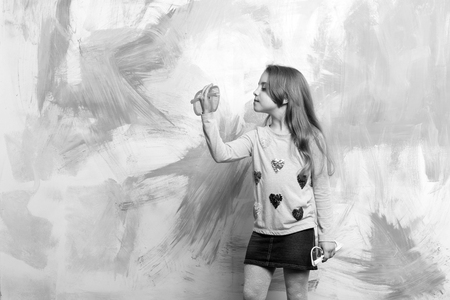 Girl with long, blond hair in fashionable clothes on colorful abstract wall. Baby model posing with two funny sunglasses. Child fashion concept.の写真素材