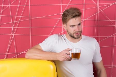 Macho with mug of mulled wine at fridge. Bachelor with morning drink at refrigerator. Man hold cup...