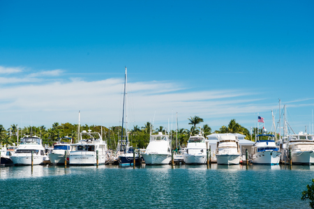 Key west, usa - February 08, 2016: yachts and sailing ships moored at sea pier on sunny blue sky. Yachting and sailing concept. Summer vacation on tropical island. Water transport and marine vessels.のeditorial素材
