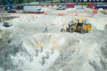 Miami, USA - October 30, 2015: workers and machinery on construction pit. Building site works on sunny outdoor. Construction and building activity. Development and engineering concept.のeditorial素材