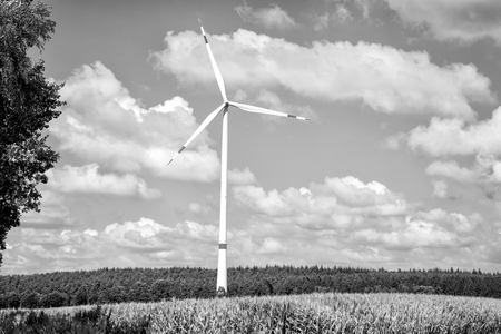 Eco power, green technology concept. Turbine on field on cloudy blue sky. Alternative energy source. Global warming, climate change. Wind farm in Lower Saxony, Germany.の写真素材