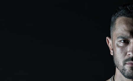 Half face of serious man. Macho with beard on unshaven face. Bearded guy with stylish haircut on black background. Hair salon or barbershop. Mens beauty or skincare and grooming, copy space.の写真素材