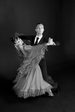 dance ballroom couple in red dress dance pose isolated on black background. sensual professional dancers dancing walz, tango, slowfox and quickstep. black and whiteの写真素材