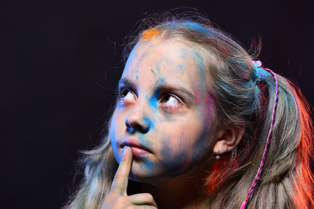 Schoolgirl has paint spots on face. Children and creativityの写真素材