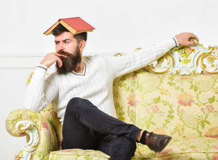Macho sits with open book on head, like roof. Boring literature concept. Man with beard and mustache...