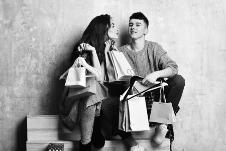 happy couple of pretty girl and young guy with packagesの写真素材