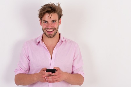 Guy with beard types message on phone. Relax and gadgetsの写真素材