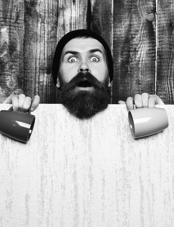 Bearded brutal caucasian hipster with paper sheet and cupsの写真素材