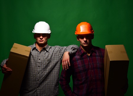 Deliverymen with serious faces easily hold cardboard boxesの写真素材
