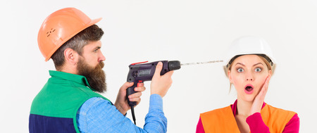 Man with drill drills head of woman, white background.の写真素材