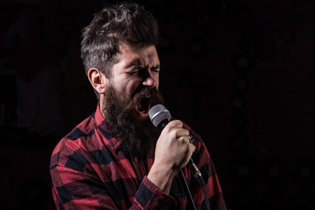 Talent show concept. Man with tense face holds microphone,の写真素材