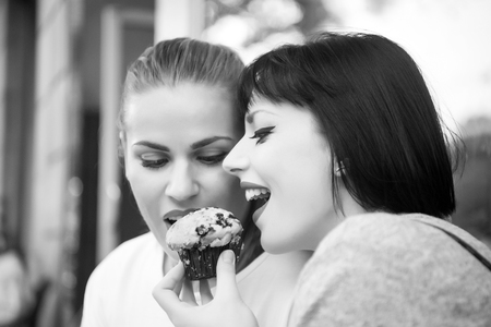 Girl friends eat blueberry muffin in paris, france. Hunger, temptation, appetite concept. Dessert, food, snack, pastry.の写真素材