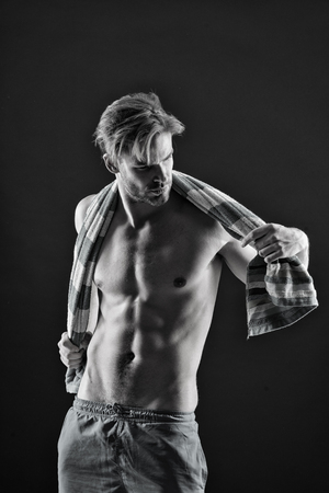 Sexy athlete wipe with towel after training. Sportsman with fit bare torso. Man with six pack and ab muscles. Sport and fitness. Hygiene or health and bodycare concept, black and white.の写真素材