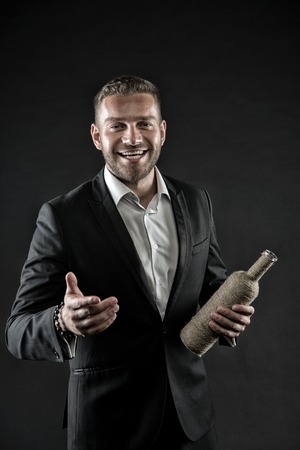 Bad habit and addiction. Happy man with bottle of wine. Businessman or groom smile in formal suit at...