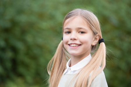 Happy childhood and childcare. Child with smile on cute face outdoor. Little girl with long blond...