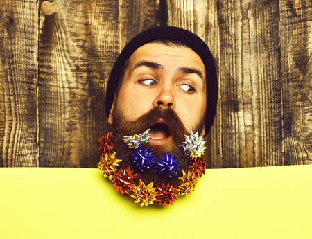 Bearded man, brutal caucasian thoughtful hipster with gift decoration starsの写真素材
