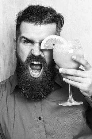 Brutal caucasian hipster holding tropical alcoholic fresh cocktailの写真素材