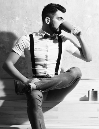 bearded man drinking coffee, tea from cup with serious faceの写真素材