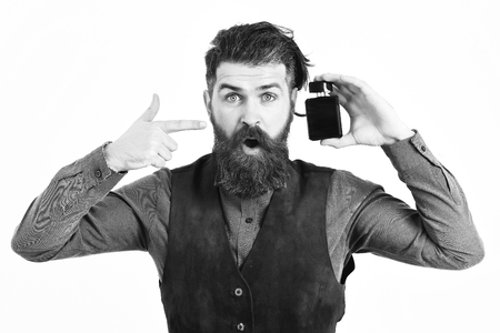bearded man holding perfume with surprised faceの写真素材