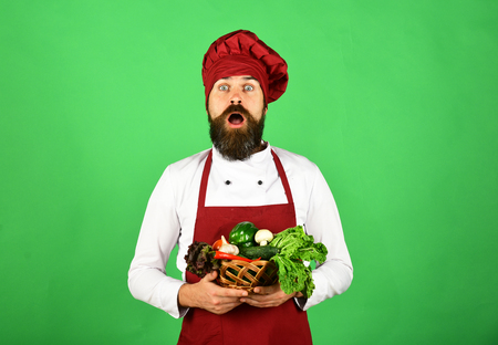 Chef holds lettuce, tomato, pepper and mushrooms.の写真素材