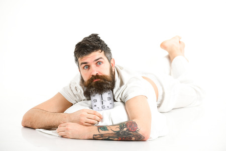 Hipster already awake lies on alarm clock, slept well,の写真素材