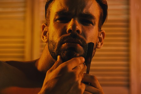 Sweet gay. Honey. Sex and healthcare concept: macho shaving chin with razorの写真素材