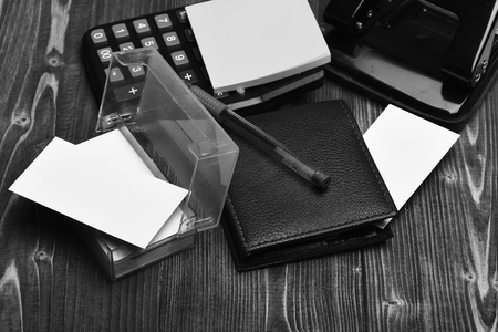 Calculator, puncher, card holder, notes and pen on vintage backgroundの写真素材