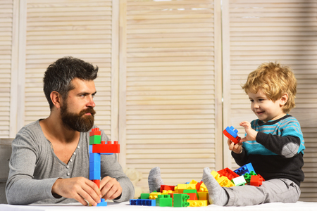 Man with beard and boy play on wooden wall backgroundの写真素材