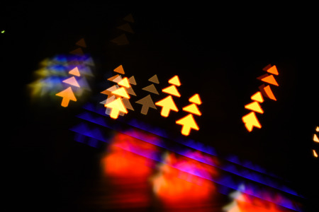 Lights of christmas garland blurred on black background. Christmas concept. Lights of colorful garland blurred as beautiful background. Christmas holiday decoration with silhouette of christmas treesの写真素材