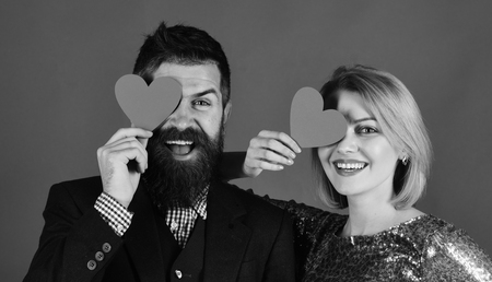 Couple in love. Happy young couple holding red paper hearts and smilingの写真素材