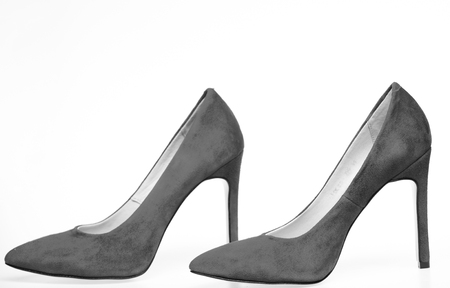 Shoes made out of red suede on white background, isolated. Pair of fashionable high heeled pump shoes. Footwear for women with thin high heels. Elegant stiletto shoes conceptの写真素材