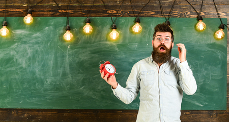 Forgot about time concept. Man with beard and mustache on shocked face in classroom. Teacher in...