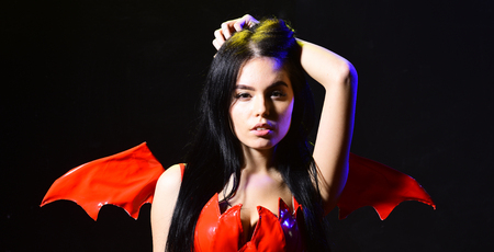 Sexy devil concept. Demon sexy girl play with hair. Girl sexy demon with wings, devil full of...