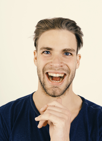 Funny Face. Guy in dark blue tshirt smiles. Man with fair hairの写真素材