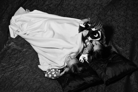 Childrens dream, Kids in pajamas sleep with teddy bears on dark background.の写真素材