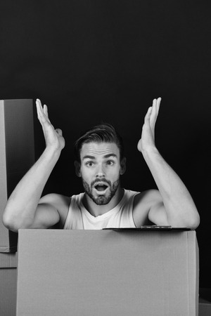 fast delivery. Guy with clip board isolated on black background. Delivery and moving in concept. Man with strong arms among cardboard boxesの写真素材