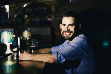 man relaxing at the bar. Guy with shot or liqueur sitting at bar counter.の写真素材