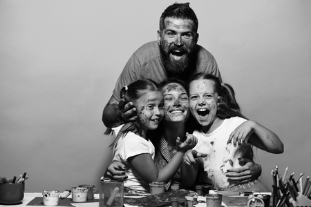 Happy family. Girls, man and woman with cheerful faces by art deskの写真素材