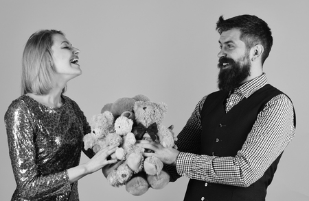 Girl and bearded man with cheerful faces play with toysの写真素材