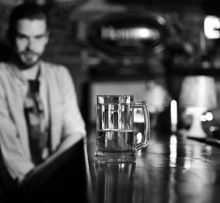 glass of beer. Glass of draft beer on blurred bar background.の写真素材